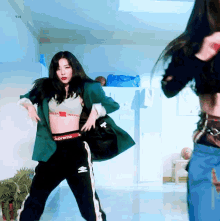 a woman in a supreme crop top and pants is dancing
