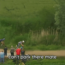a man riding a bike on a dirt road with the words " can 't park there mate " above him