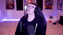 a man wearing glasses and headphones is sitting in front of a microphone