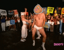 a man and a woman are dancing in front of a crowd holding signs including one that says blink 182