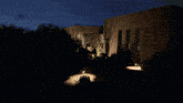 a house is lit up at night with a car parked in front of it