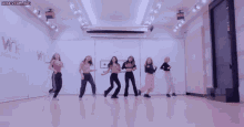 a group of young girls are dancing in front of a sign that says secret jumbo