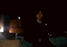 a blurry picture of a person in a dark room with a light behind them
