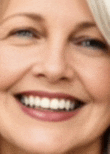 a close up of an older woman 's face with a smile on her face .