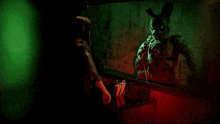a woman is standing in front of a mirror looking at her reflection in the mirror ..
