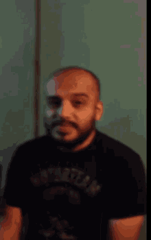 a man with a beard is wearing a black shirt that says motorteam