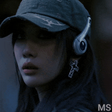 a woman wearing a hat and headphones has the letters ms on the bottom