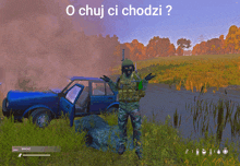 a man standing next to a blue car with the words o chuj ci chodzi written on the screen