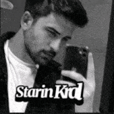 a man taking a picture of himself with the name starin kid