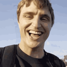 a man wearing a black shirt is smiling with his mouth wide open