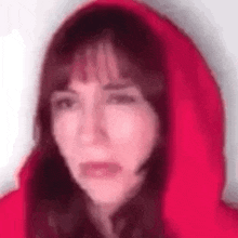 a blurry picture of a woman wearing a red hooded jacket .