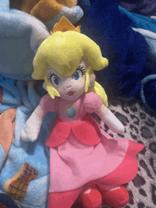 a stuffed princess peach doll is laying on a blanket