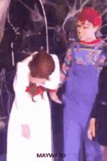 a man in overalls is standing next to a woman in a white dress