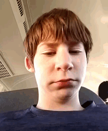 a young boy making a funny face while sitting on a bus