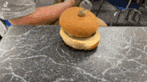 a hamburger with a light bulb on top of it is on a table with a tiktok watermark