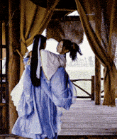 a woman in a blue dress is hugging a woman in a white dress