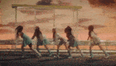 a group of girls are dancing in front of a bus stop at sunset