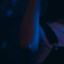 a blurred image of a person 's arm with a blue background