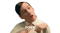 a man in a plaid shirt and tie says " do n't " with his hands