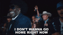 a man in a cowboy hat says " i don t wanna go home right now " in front of a crowd