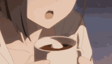 a close up of a person holding a cup of coffee with a marshmallow in it