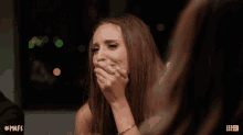 a woman with a ring on her finger is crying