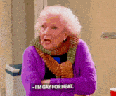 an elderly woman in a purple sweater and scarf says i 'm gay for heat