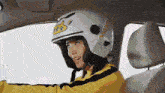 a woman wearing a white helmet with a sticker that says ' safety ' on it