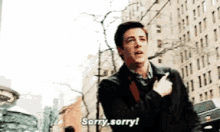 a man is standing in front of a building and saying sorry sorry .