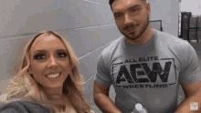 a man and a woman are posing for a picture and the man is wearing a shirt that says aew wrestling