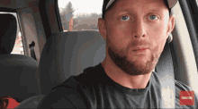 a man with a beard is sitting in the back seat of a car with a subscribe button in the corner