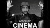 a black and white photo of a man wearing headphones and a hat that says absolute cinema on it