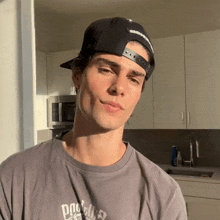 a young man wearing a hat and a t-shirt that says ' duck ' on it