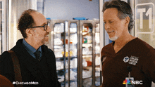 two men are standing next to each other and one of them is wearing a chicago medical center uniform