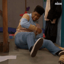 a man is laying on the floor with a nick logo in the background