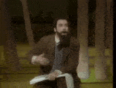 a man with a beard is holding a piece of paper with the words but to see below him