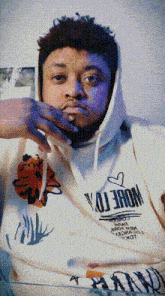 a man wearing a white hoodie that says " more " on it
