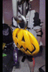 a yellow pumpkin with a face on it is hanging from a chain