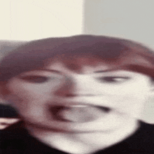 a woman with red hair is making a funny face with her tongue out .