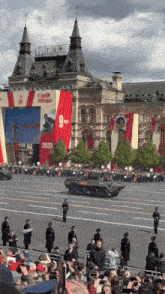 a crowd of people watching a military parade in front of a building that says gym on it