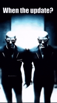 two men in suits are standing next to each other in a dark room with the words `` when the update ? '' above them .