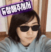 a woman wearing sunglasses has a sticker on her head that says ' a ' on it