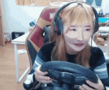 a girl wearing headphones holds a steering wheel
