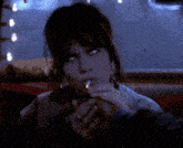 a woman is smoking a cigarette with a ring on her finger