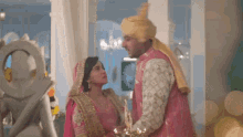 a bride and groom are standing next to each other in a room .
