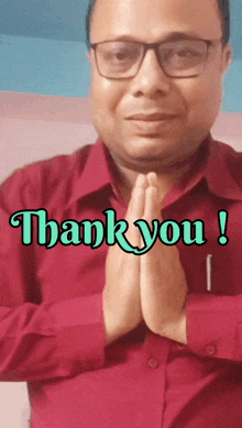 a man wearing glasses and a red shirt says " thank you "