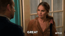 a woman in a brown shirt says great in front of a man