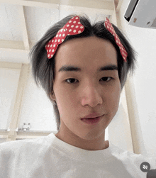 a young man with a bow in his hair