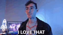 a man wearing glasses is standing in front of a computer and says i love that