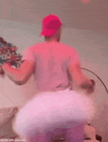 a man wearing a pink tutu and a pink hat is standing in a living room .